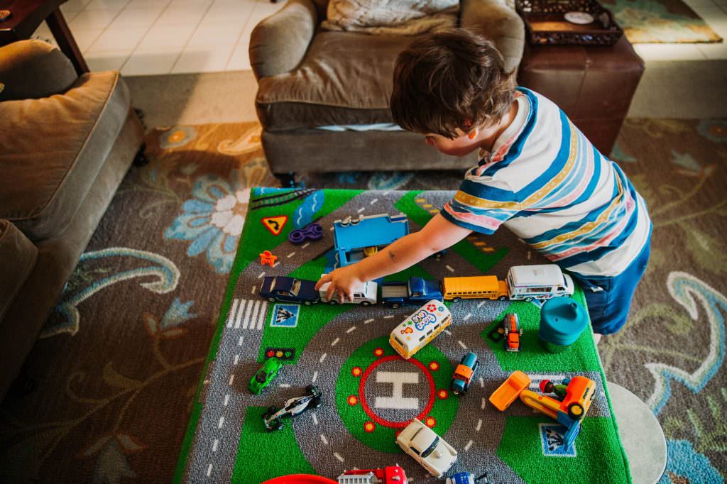 small boy playing with toy cars